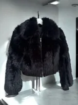 Campera corta de piel sintética negra con cierre metálico plateado.
