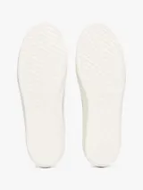 Zapatillas Tommy Jeans blancas de corte bajo con refuerzos de goma, suela vulcanizada con línea negra y logo en el lateral.