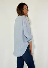 Camisa celeste de lino con mangas 3/4 abullonadas y cuello en V con volados.