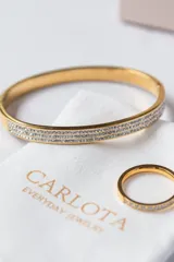Anillo dorado tipo cintillo con hilera de circonitas engarzadas.