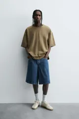 Camiseta color beige de corte holgado, cuello redondo y manga corta.