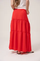 Falda larga roja de gasa con volados y cintura ajustable con cordón.