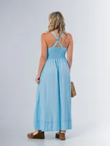 Vestido largo celeste en denim liviano con spandex, de corte amplio y espalda cruzada con drapeado elastizado.