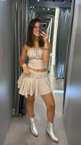 Minifalda beige con textura, tiro bajo y corte acampanado. No incluye cinturón.