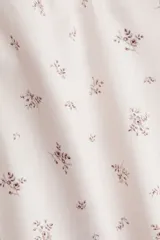 Pantalón de pijama de corte holgado en algodón con estampado de flores pequeñas. Modelo de tiro bajo con elástico revestido en la cintura, cordón para ajustar fino y piernas rectas, levemente acampanadas.