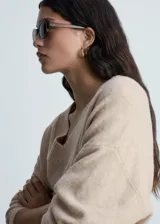 Sweater color beige de tejido de punto con cuello en V y corte oversize.