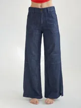 Pantalón jean de corte ancho, color azul oscuro, con bolsillos frontales y traseros, y costuras rojas.