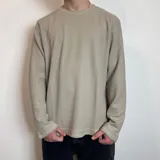 Buzo color beige de micropanal, corte regular y cuello redondo.