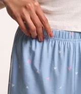 Conjunto de pijama short doll confeccionado en ribana, compuesto por musculosa y short con elástico en la cintura y estampado de corazones.