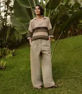 Pantalón wide leg color beige, de corte sastrero, con pliegues delanteros y cinturón.