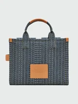Bolso tote mediano de denim con monograma de la marca Marc Jacobs, con doble asa de mano de cuero y correa bandolera ajustable de tela.