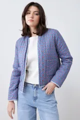 Chaqueta capitoneada reversible con estampado floral multicolor y ribete azul.