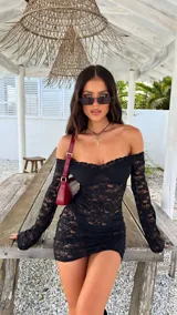 Vestido corto de encaje negro con escote off-shoulder y mangas largas acampanadas.