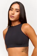 Top deportivo negro con cuello halter y espalda descubierta. Confeccionado en poliamida y elastano con protección UV50+.