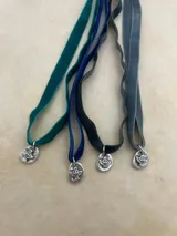 Gargantilla de terciopelo con dije plateado con forma de paloma.