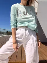 Remera celeste de manga larga con cuello redondo y estampado con letras y números.