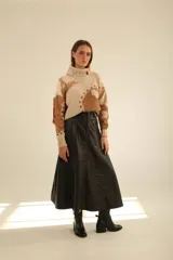 Falda midi de cuero negro, corte evasé y costuras a la vista en color marrón.