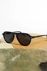 Lentes de sol negros con marco aviador y lentes oscuros.