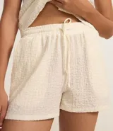 Bermuda color crema de poliéster y elastano, con cintura elástica con lazo y textura chambray.