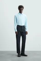 Camisa negra de manga larga con cuello italiano abierto y cierre frontal de botonadura. Corte slim fit.