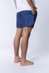Short de baño azul con estampado de hojas en tonos más oscuros.