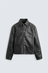 Cazadora cropped fit confeccionada en tejido efecto piel color negro. Tiene cuello solapa, manga larga con puño abotonado, bolsillos de vivo en cadera y bolsillo interior. El cierre es frontal con botones a presión.