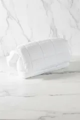 Bolso de hombro acolchado color azul eléctrico, con diseño de cuadrícula y correa ancha ajustable con hebilla metálica.