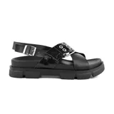 Sandalias negras de cuero sintético con plataforma track y hebilla metálica.