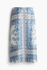 Pollera midi de lyocell con estampado paisley en tonos azules y blancos, de corte holgado, tiro alto y cierre lateral oculto.