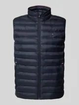 Chaleco acolchado azul marino de nailon reciclado, con cuello alto, cierre de cremallera, bolsillos laterales y logo de Tommy Hilfiger bordado en el pecho.