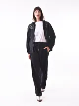 Campera deportiva negra con capucha, cierre frontal y apliques de lentejuelas en los hombros.