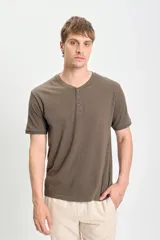 Remera verde de manga corta con cuello redondo y tapeta con tres botones.