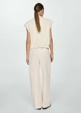 Pantalón de vestir color crema, de corte recto y largo, con pinzas delanteras, bolsillos laterales y trabillas. Confeccionado en tejido de mezcla de lyocell, algodón y lino.