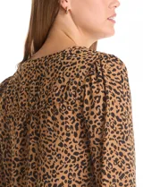 Blusa de gasa estampada con animal print, cuello a la base con escote en V y cierre dorado. Manga larga con puño elastizado.