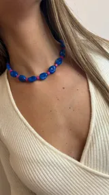 Collar corto con cuentas grandes de color azul y cuentas pequeñas cilíndricas de color fucsia.