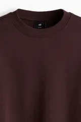 Buzo de tejido de mezcla de algodón de peso medio con interior cepillado suave. Modelo con cuello redondo ribeteado, hombros caídos y remate acanalado ancho en puños y bajo. Corte holgado.