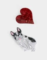 Set de dos broches para el pelo: uno con forma de bulldog francés blanco con manchas negras y otro con forma de corazón rojo con textura brillante.