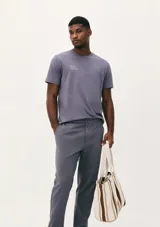 Camiseta blanca de algodón con cuello redondo y mangas cortas. Estampa rectangular con borde negro que contiene la frase "NATURAL ATMOSPHERE" en letras mayúsculas y una imagen de montañas y mar.