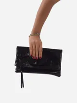 Sobre de fiesta negro charolado con cierre de solapa imantada y tira de cuero para sujetar a la muñeca.