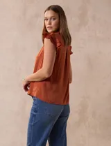 Camisa azul de satén, marca Alex & Lili. Cuello a la base con solapa, escote en V, apertura central con botones y sisa con volados.