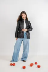 Cazadora negra de cuero sintético con cuello mao, cierre frontal con cremallera y bolsillos laterales con solapa.