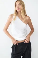 Top blanco de punto con diseño asimétrico y cuello tipo bufanda.