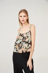 Musculosa con estampado floral multicolor sobre fondo negro, breteles anchos y escote cuadrado.