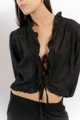 Blusa color blanco de lino, con mangas 3/4 y volados en el frente. Se ata con lazos en el centro.