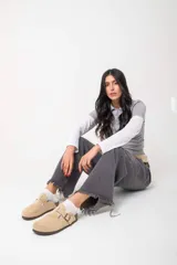 Mocasines negros de cuero con hebilla dorada y suela de corcho.