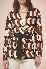 Saco con estampado geométrico en tonos blanco, negro y naranja, con cuello en V, mangas largas y lazo negro para ajustar en la cintura.
