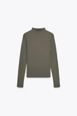 Camiseta blanca de manga larga con cuello alto y corte ajustado.
