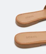 Sandalias planas color crema con puntera cuadrada y tiras anchas en forma de H.