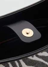 Bolso tipo bucket con estampado de cebra, asa corta y cierre de botón magnético.