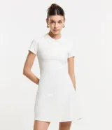 Vestido corto blanco de rib, con cuello polo, botones delanteros y mangas cortas.